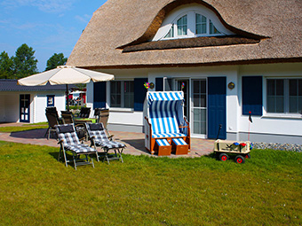 Die große Terrasse mit Gartenstühlen, Tisch, Liegen und Strandkorb